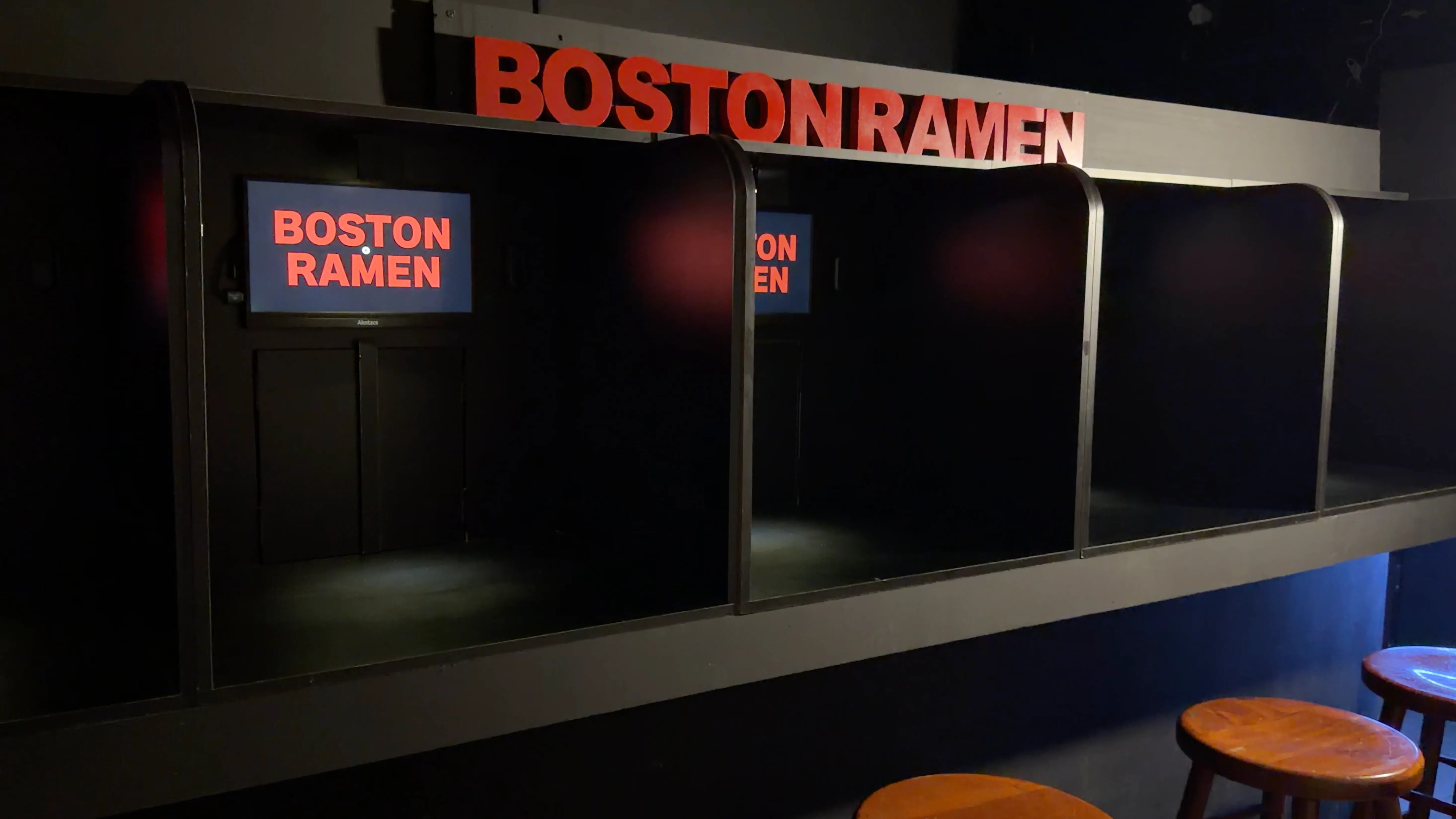 The five-seat BOSTON RAMEN Theater Box, with individual screens and the illuminated BOSTON RAMEN sign.